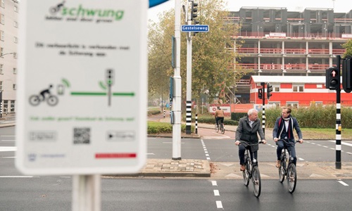 Foto van twee fietsers op een fietspad en een bord met over Swung applicatie