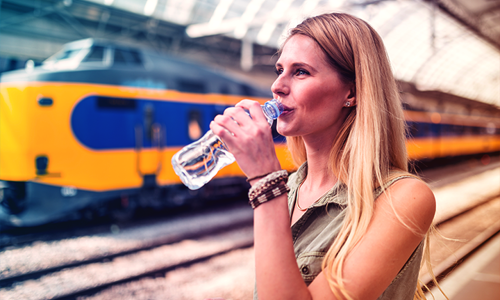 Foto dame met flesje water voor trein.png